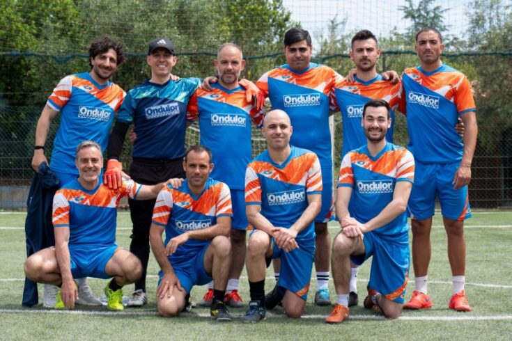 La squadra di Ondulor in divisa sportiva posa sul campo da calcio durante l’evento Aziende in Campo.